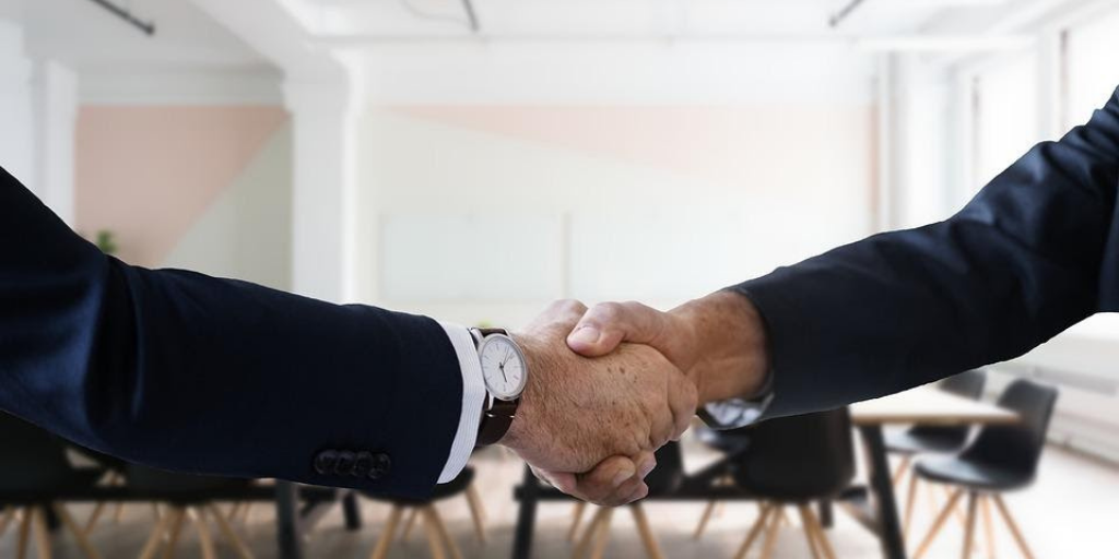 Recruitment agents shaking hands to close a deal